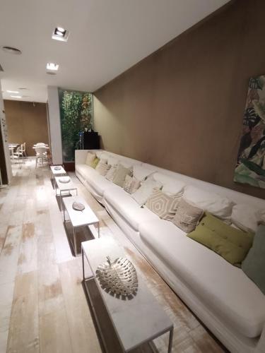 a living room with a large white couch and tables at CasaCalma Hotel in Buenos Aires