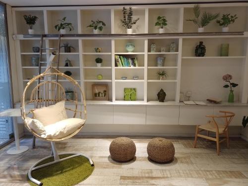 a room with a chair and shelves with potted plants at CasaCalma Hotel in Buenos Aires