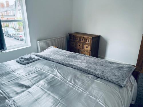 a bed with a blanket and a dresser in a bedroom at 21 ,North Street in Shrewsbury