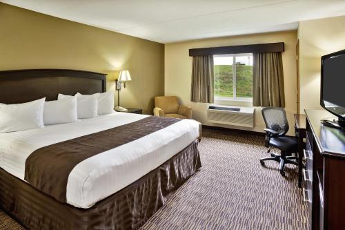 a hotel room with a large bed and a television at AmericInn by Wyndham Beaver Dam in Beaver Dam