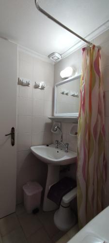 łazienka z umywalką i zasłoną prysznicową w obiekcie Porphyra w mieście Potamós