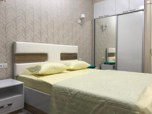 um quarto com uma cama grande e almofadas amarelas em Huvaydo Residence Apartment em Tashkent
