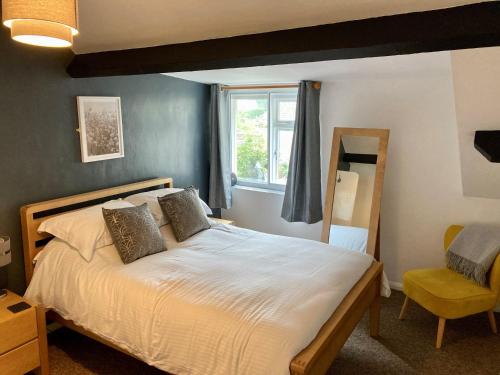 1 dormitorio con 1 cama grande y ventana en Briscoe Lodge Self Catering Apartments en Windermere