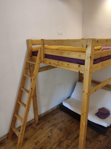 Ce lit superposé se trouve dans un dortoir avec une échelle. dans l'établissement L'Aile Ouest en permaculture, à Bergerac