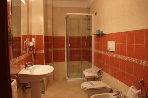 a bathroom with a shower and a toilet and a sink at Ranch Palace Hotel in Naples