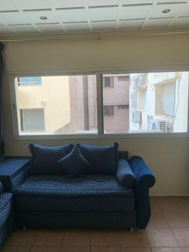 um sofá num quarto com uma grande janela em Appartement a louer centre ville em Fez