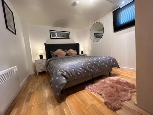 una camera con un letto e un tappeto peloso di koselig leilighet nær EB stranda ad Arendal