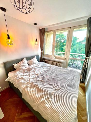 a bedroom with a large bed in front of a window at Luxurious BOHO style apartm. *HOME OFFICE* +Desk in Katowice