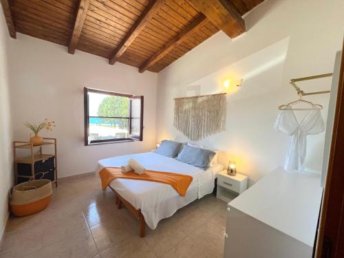 a bedroom with a bed and a window at SURFING COTTAGES in Gizzeria