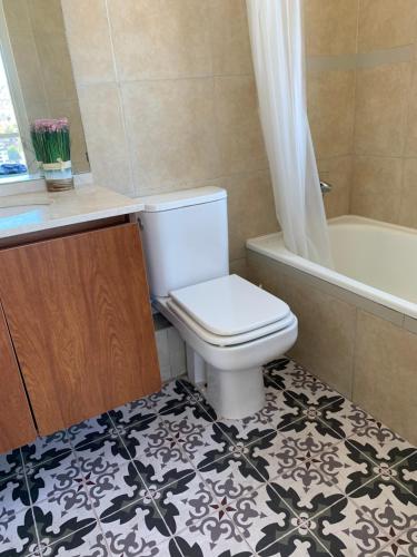 a bathroom with a toilet and a tub and a sink at Apartemento tres Norte in Viña del Mar