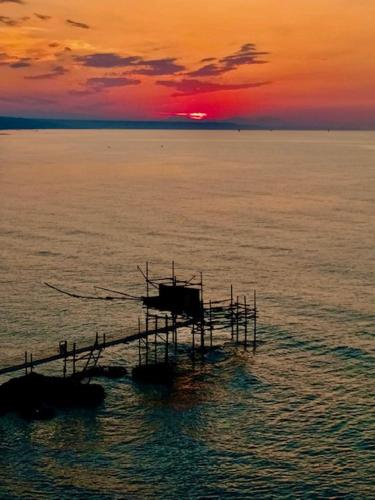 a boat in the ocean with a sunset in the background at VASTO centro Alloggio 1-2-3 in Vasto
