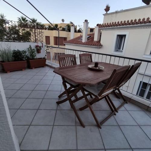 a wooden table and two chairs on a patio at Plaka's Heart in Athens