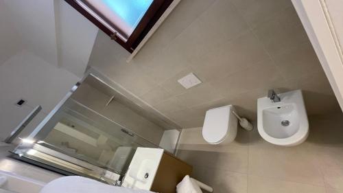 a bathroom with a white toilet and a urinal at Hotel Boschetto in Follonica