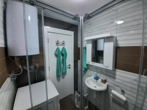 a bathroom with a sink and a toilet and a mirror at Apartman TEJA DELUXE in Vrnjačka Banja
