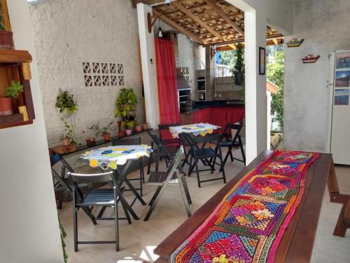 a patio with two tables and chairs with a rug at CASA DA ANA E ZÉ in Governador Celso Ramos