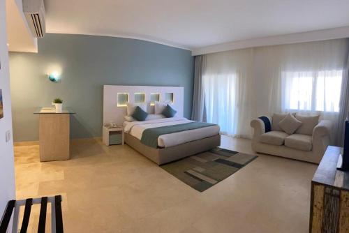 um quarto com uma cama, um sofá e uma cadeira em Azzurra Sahl Hasheesh em Hurghada