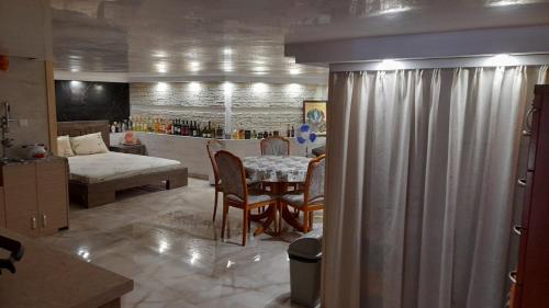 a living room with a table and a room with a bed at Sea View Marina Dinevi Apartments - Tryavna Beach in Sveti Vlas