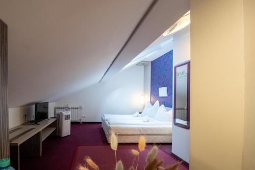 a hotel room with a bed and a tv at AMADEA - Cityhotel Salzburg in Salzburg