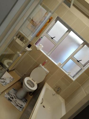 a small bathroom with a toilet and a window at Menlyn Mews Guesthouse in Pretoria