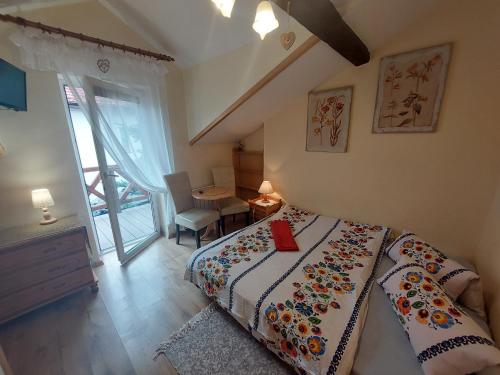 Schlafzimmer mit einem Bett, einem Tisch und einem Fenster in der Unterkunft Pokoje Gościnne "Justyna" in Kroczyce