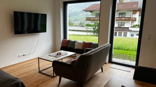 a living room with a tv and a couch and a table at Studio11 in Neustift im Stubaital