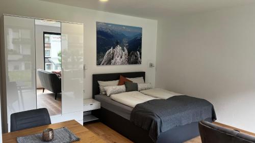 a bedroom with a bed and a table and a mirror at Studio11 in Neustift im Stubaital