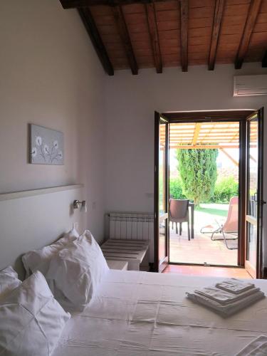 a bedroom with a bed and a sliding glass door at Agrialbergo Capalbio La Sugherella in Capalbio