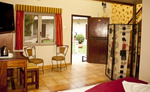 a living room with a table and chairs and a kitchen at Paloma Hotel Ring Road in Accra