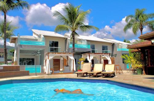 una casa con piscina y palmeras en Pousada Villa del Sol, en Paraty