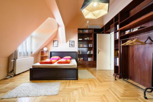 una camera da letto con un letto con cuscini rosa di View to the Roofs Luxury Apartment with 2 Bedrooms a Budapest