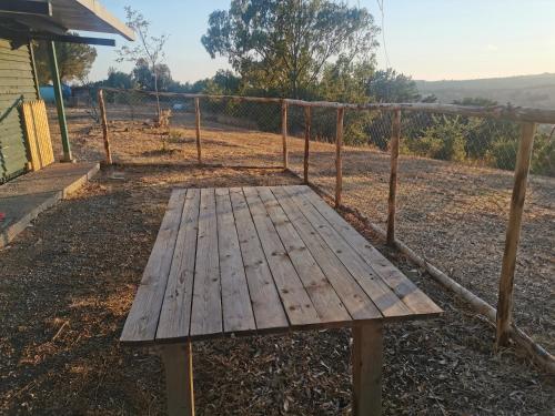un banco de madera sentado frente a una valla en Podere del Sole 2 en Santa Marinella