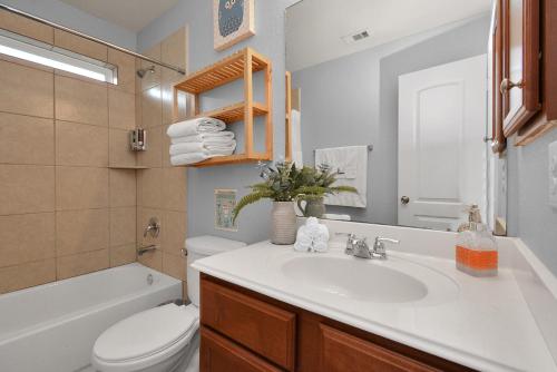 a bathroom with a white sink and a toilet at Neighborly Home Near Katy, Energy Corridor in Houston