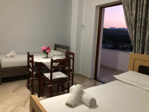 a room with two beds and a table and a window at Vila Jeti in Ksamil