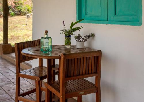 a wooden table with two chairs and a bottle of wine at Finca San Pedro in Barichara