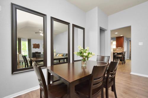 a dining room with a wooden table and mirrors at Early Green Home Sleeps 6 Yard King Suite in Houston