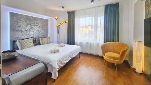 1 dormitorio con 1 cama, 1 silla y 1 ventana en Main square 5 star luxury apartment with view, en Cluj-Napoca