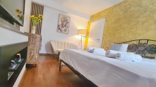 a bedroom with a bed with white sheets and a fireplace at Main square 5 star luxury apartment with view in Cluj-Napoca