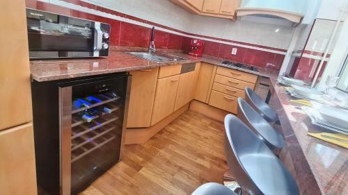 a kitchen with a black dishwasher and a microwave at Main square 5 star luxury apartment with view in Cluj-Napoca