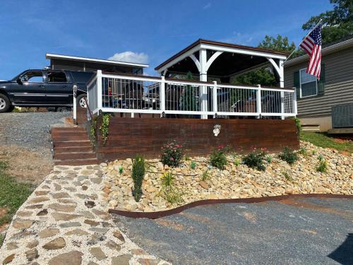 une maison dotée d'une terrasse couverte avec un drapeau. dans l'établissement Robins Nest, à New London