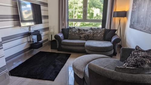 a living room with a couch and a chair at Modern Quiet City Center Airport 2 Bedroom Apartment in Edinburgh