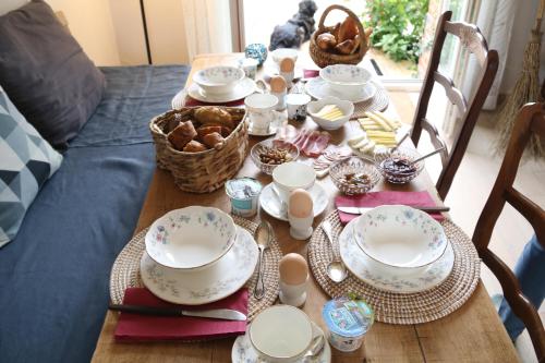 einen Tisch mit Tellern und Geschirr darauf in der Unterkunft Manoir du Taillis in Heugon