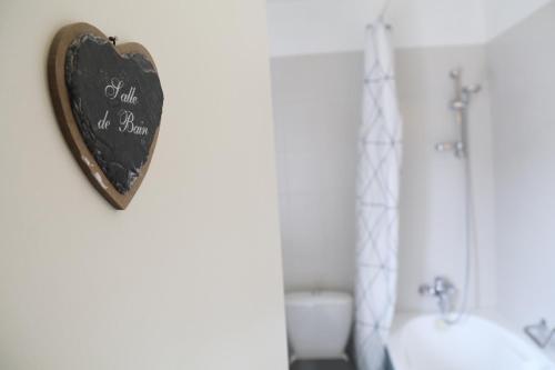 a heart shaped sign on the wall of a bathroom at Manoir du Taillis in Heugon
