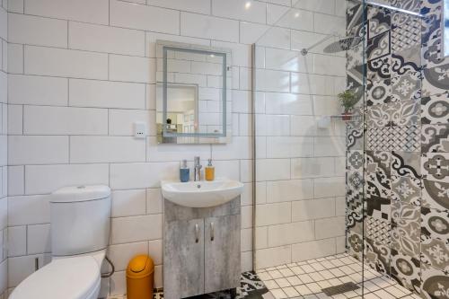 a bathroom with a sink and a toilet and a mirror at Hampton Collection - Stylish 3 Sleeper Apartment with Pool in Durban