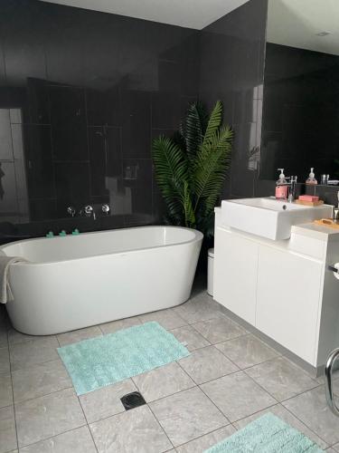 Luxury 3 bdm Spacious apt in the heart of Wagga في واجا واجا: حمام مع حوض أبيض ومغسلة