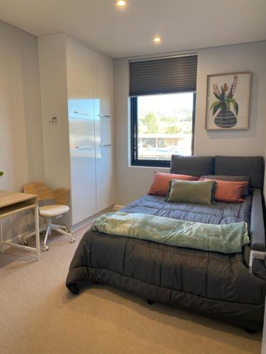 a bedroom with a bed and a desk and a window at Luxury 3 bdm Spacious apt in the heart of Wagga in Wagga Wagga