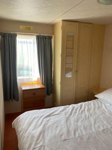 a bedroom with a white bed and a window at G3 Holiday Caravan in Par