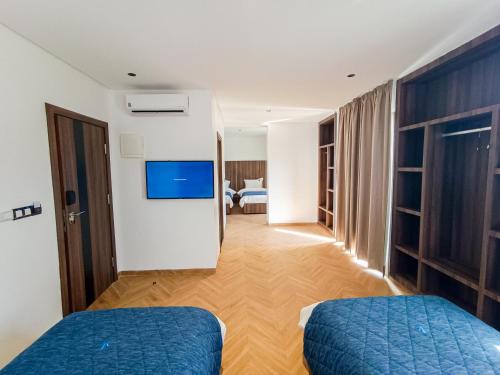 Habitación de hotel con 2 camas y TV de pantalla plana. en Hôtel La Perla, en Alhucemas