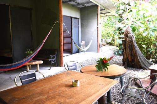 a patio with a wooden table and chairs and hammocks at Pachamama Tropical Garden Lodge in Carmen
