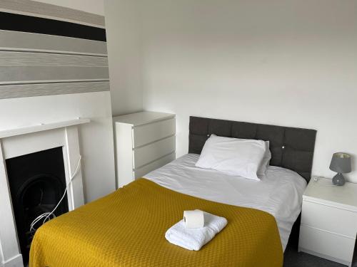 sypialnia z łóżkiem z dwoma ręcznikami w obiekcie Golden Triangle Budget Rooms w mieście Norwich