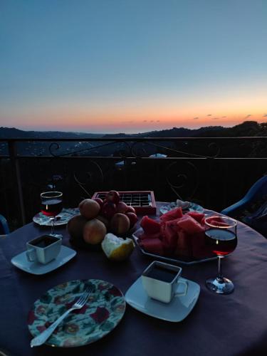 a table with plates of food and glasses of wine at Guest House MARTA in K'obulet'i